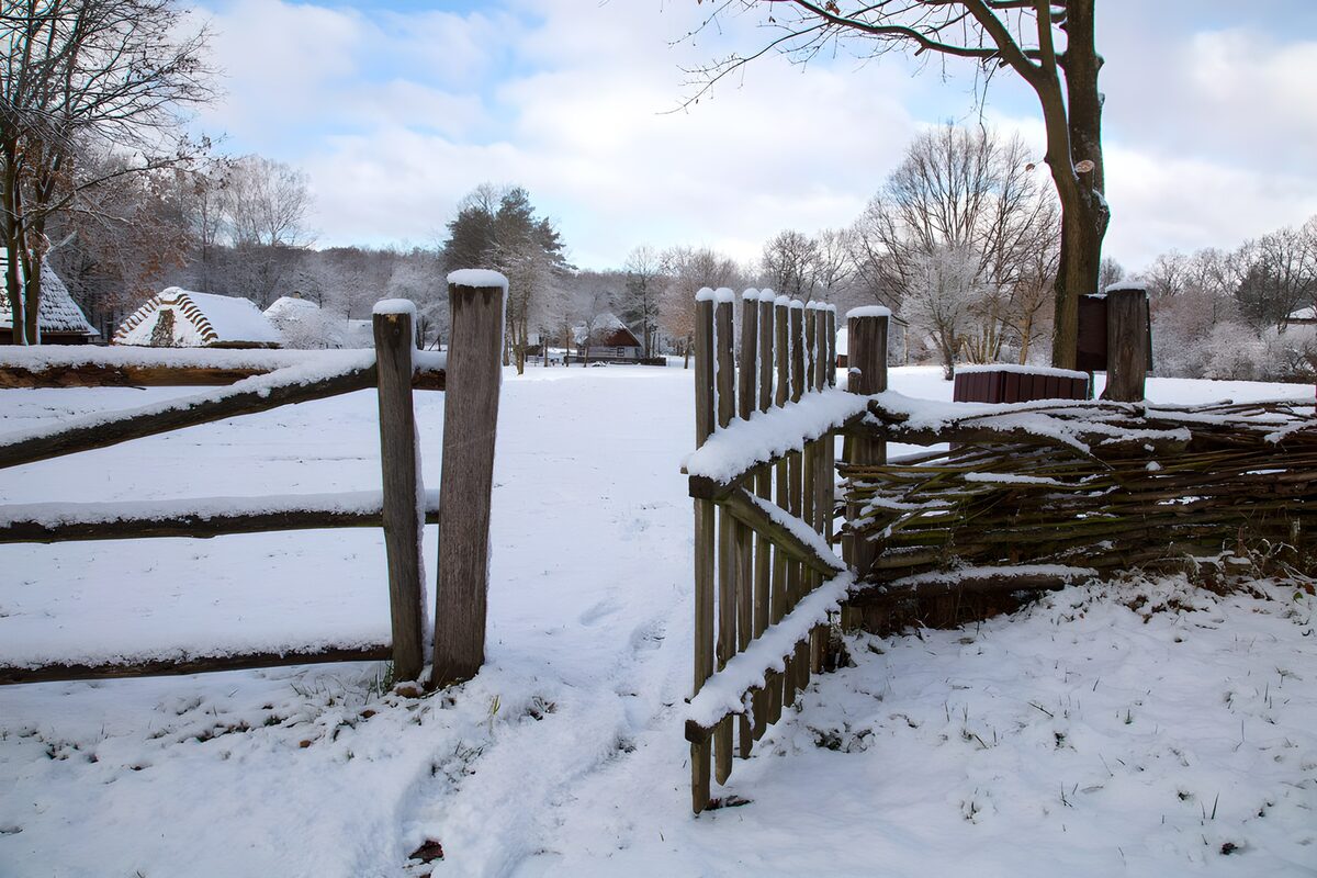 Open houten hek in een sneeuwlandschap