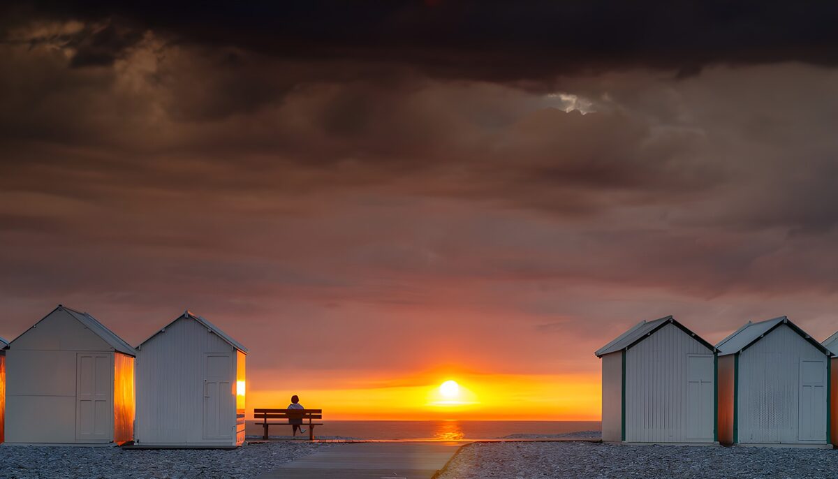 Witte strandhuisjes bij zonsondergang
