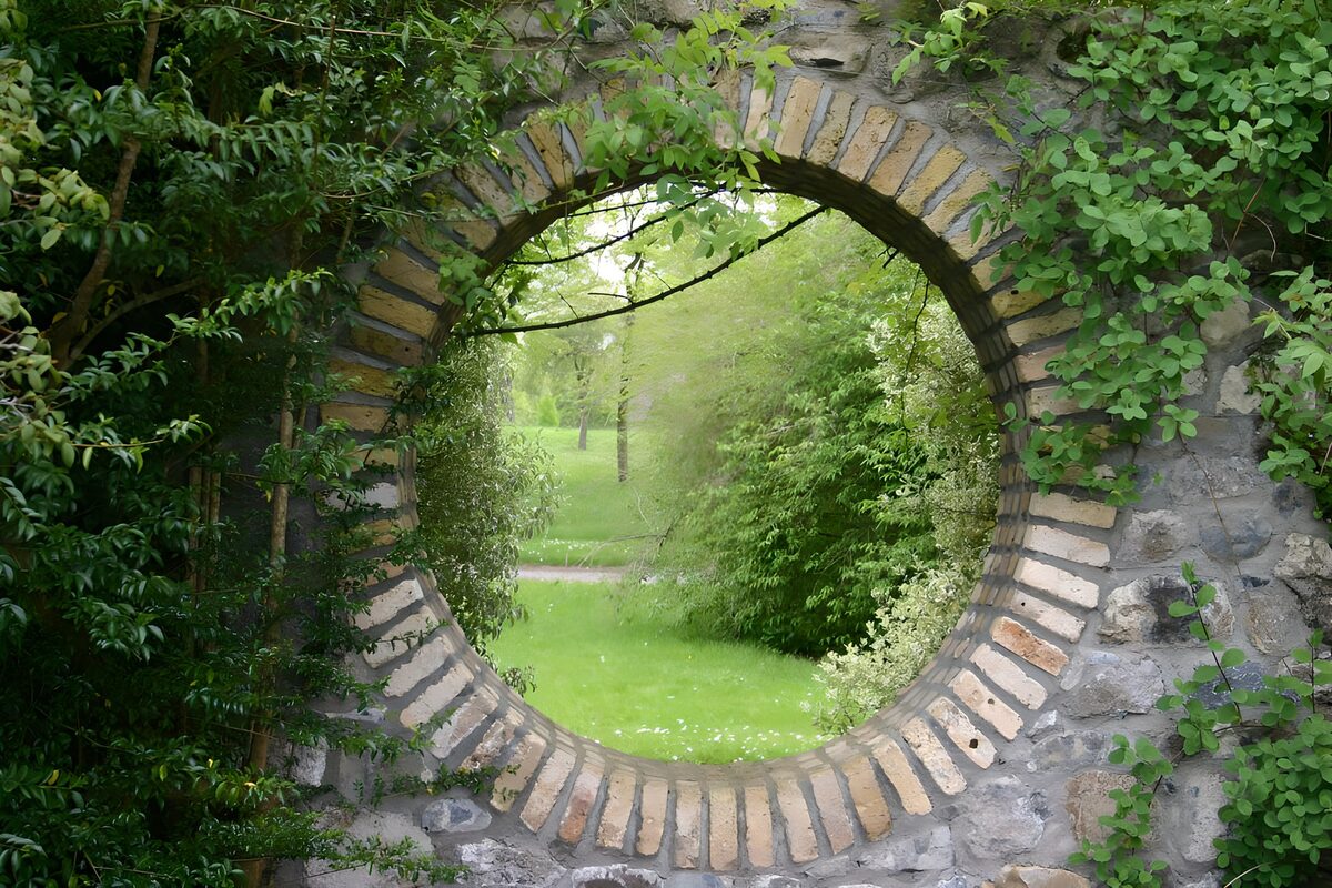 Tuinzicht door een ronde stenen opening