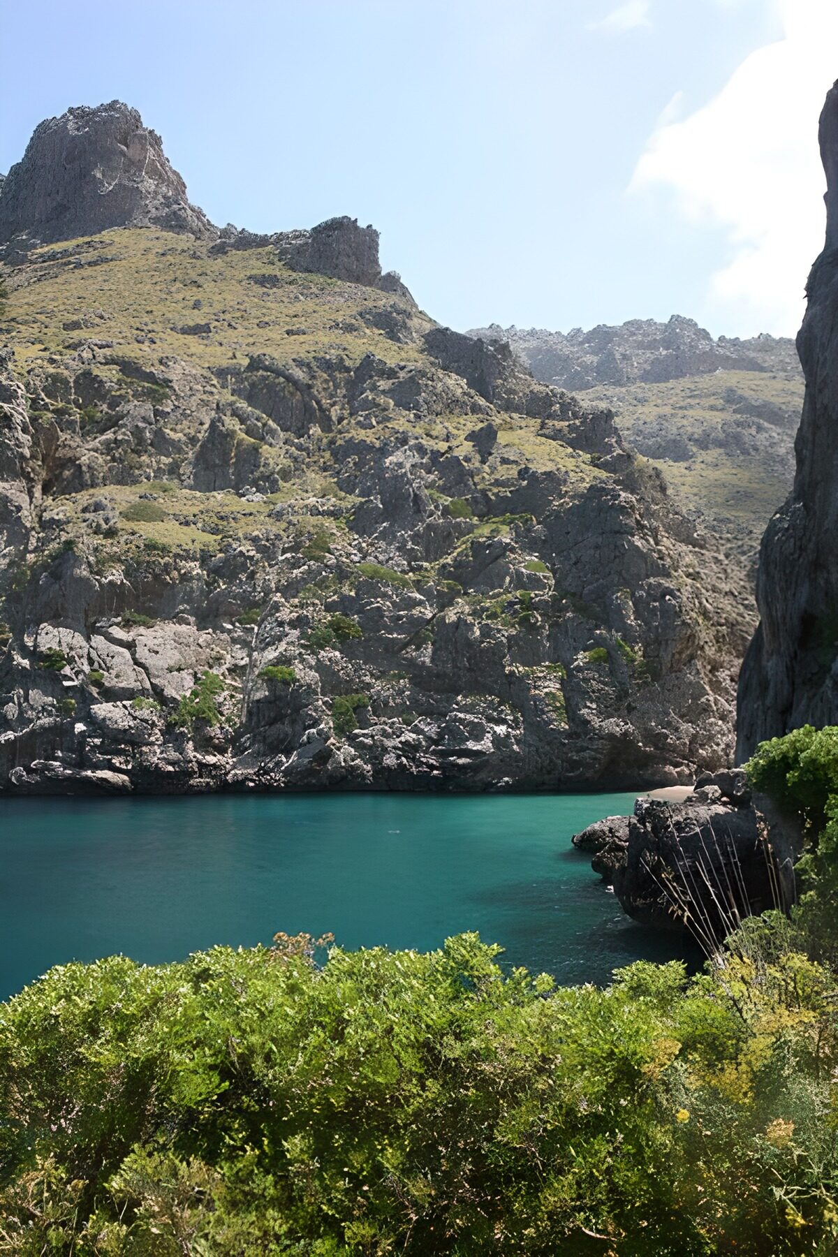 Turquoise baai tussen ruige rotsen