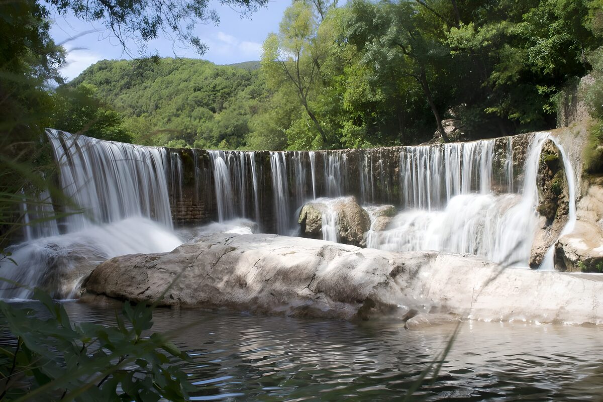 Brede waterval tussen groen en rotsen