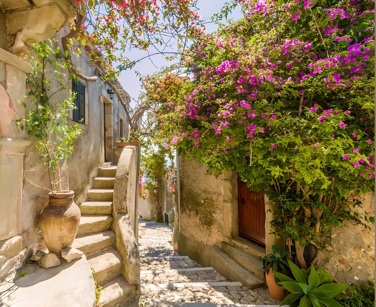 Zonnige steeg met roze bougainvillea