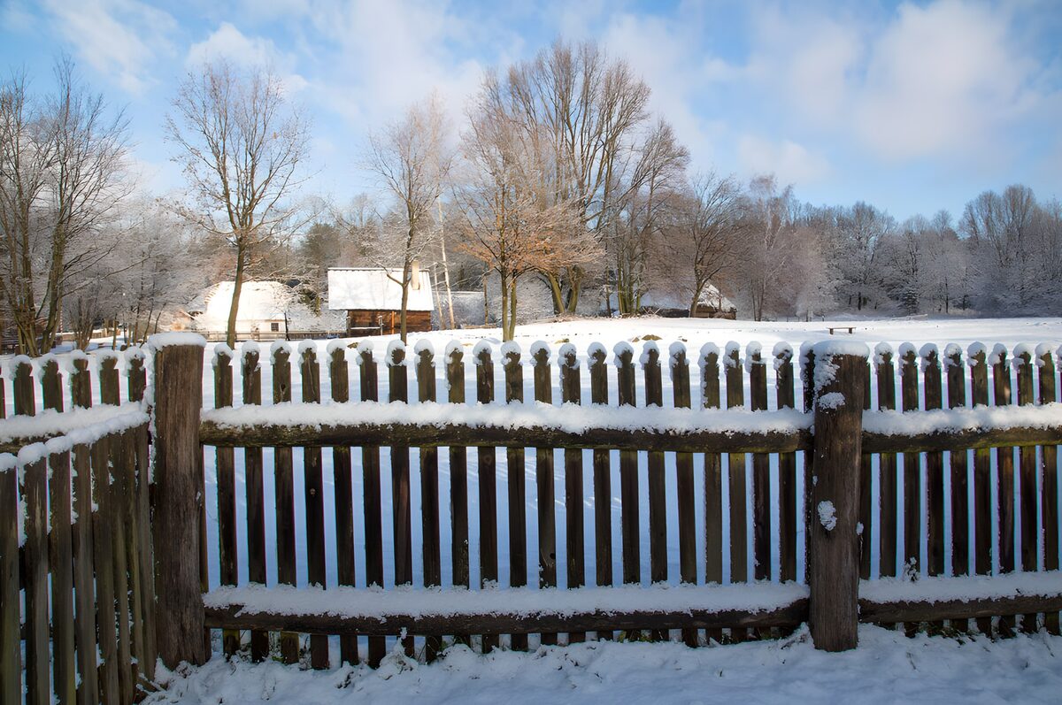 Houten hek in een besneeuwd landschap