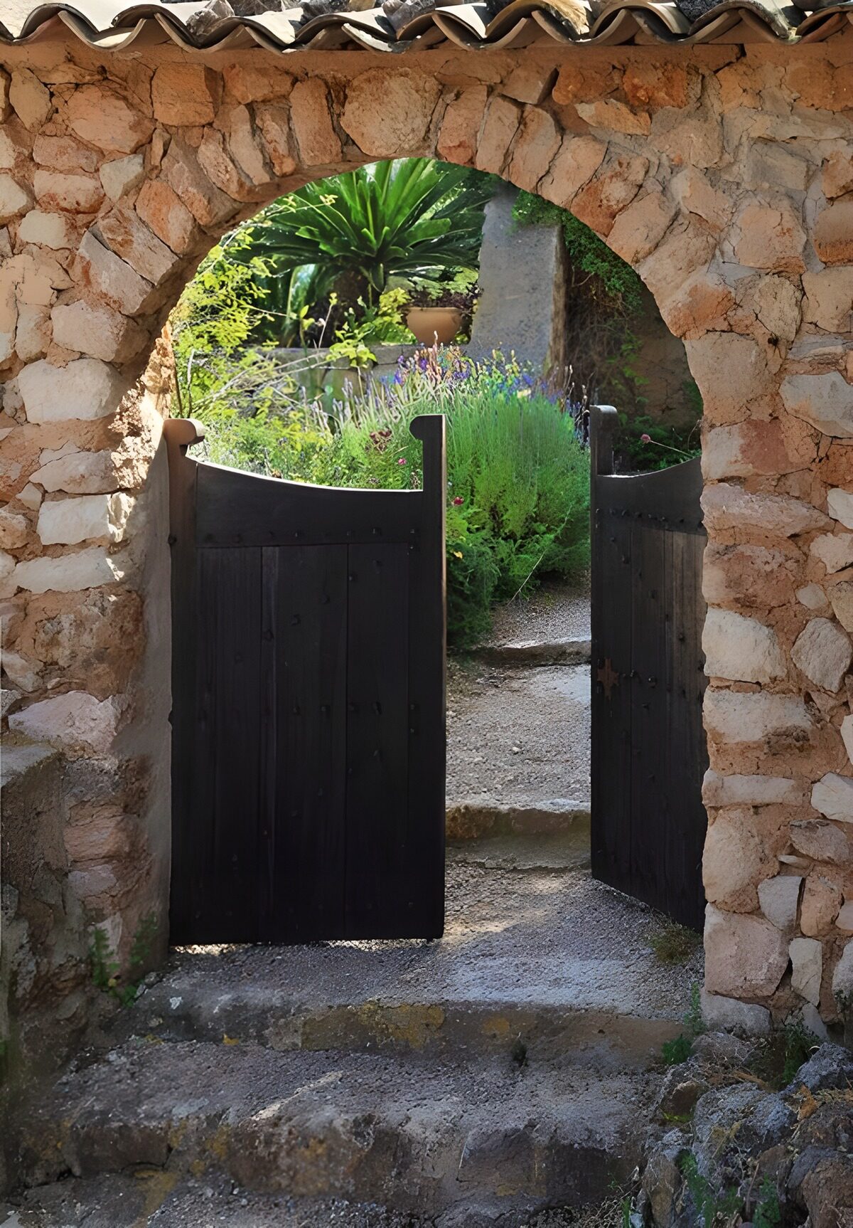 Open tuinpoort in een rustieke stenen boog