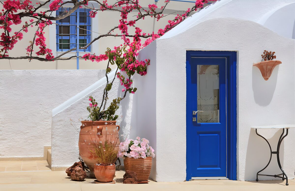 Blauwe deur met roze bougainvillea