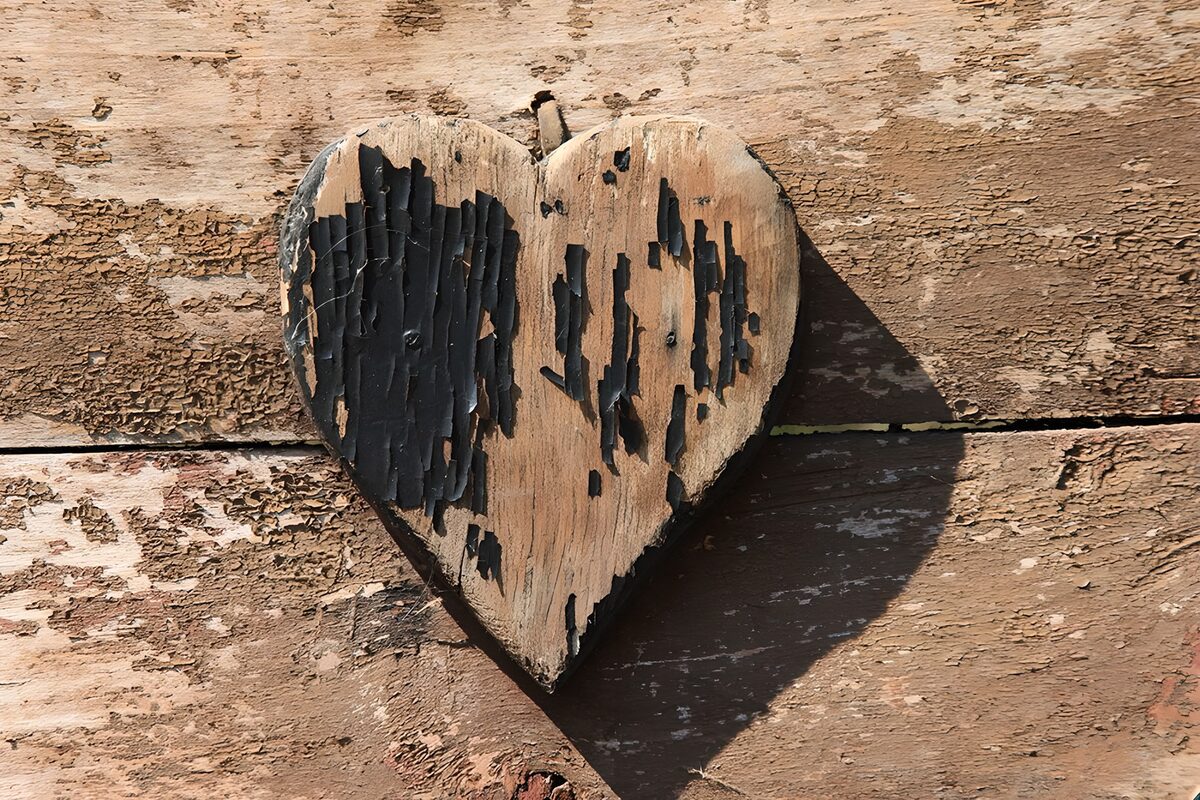 Verweerd houten hart op een plankenwand