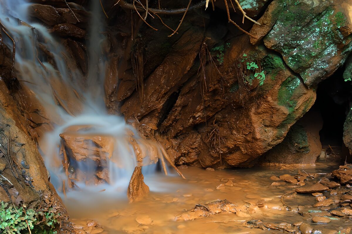 Kleine waterval tussen roestbruine rotsen