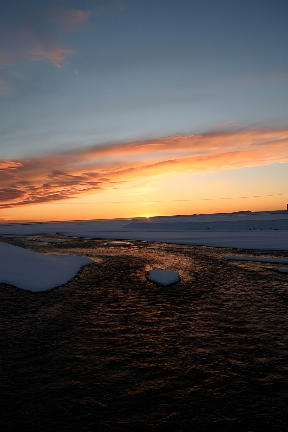 Winterwater onder een oranje hemel