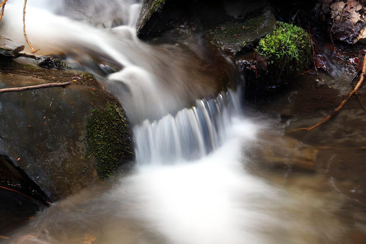 Kleine waterval tussen donkere rotsen