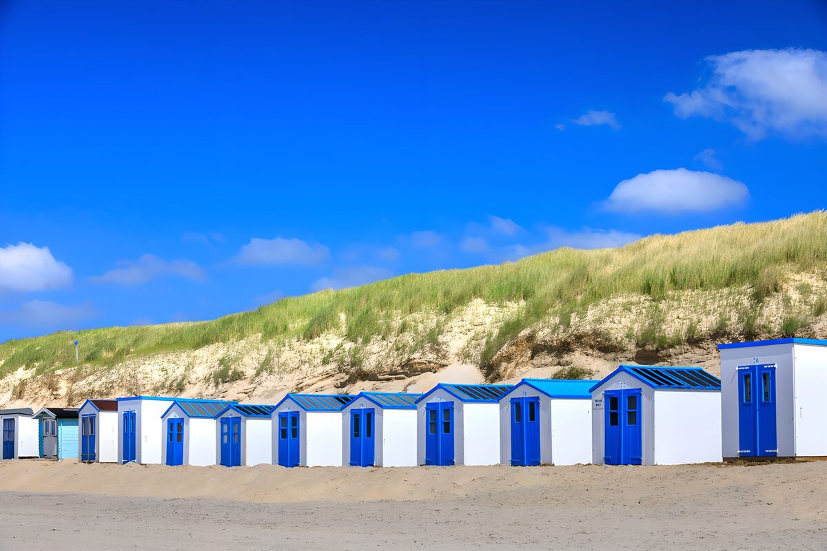 Witte strandhuisjes onder een blauwe lucht