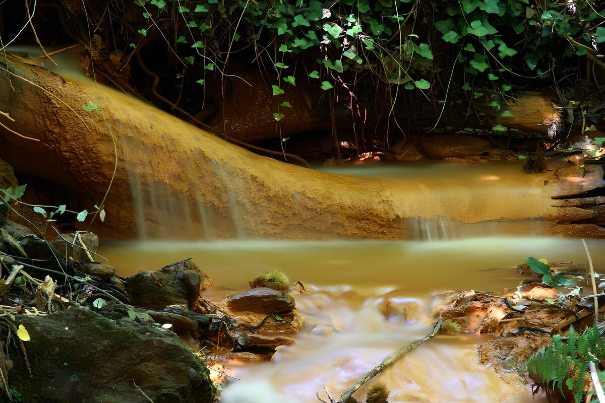Kleine waterval over okerkleurige rotsen