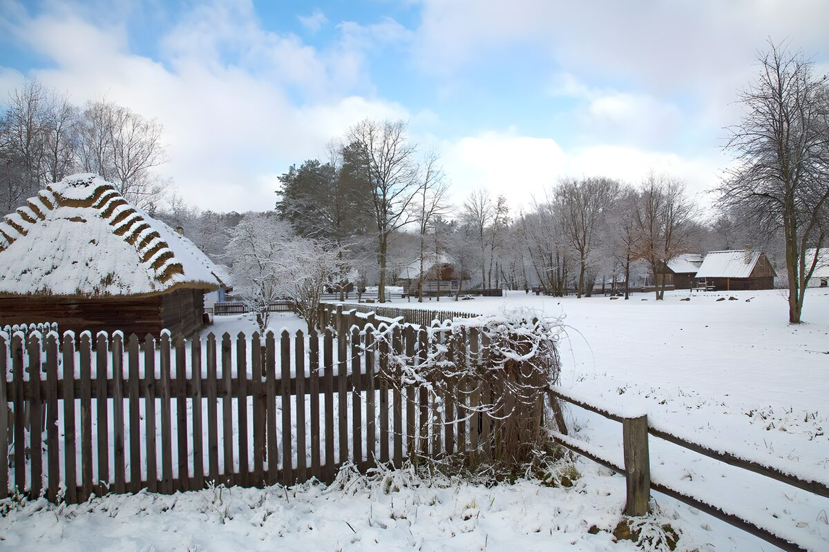 Besneeuwde hut achter het houten hek