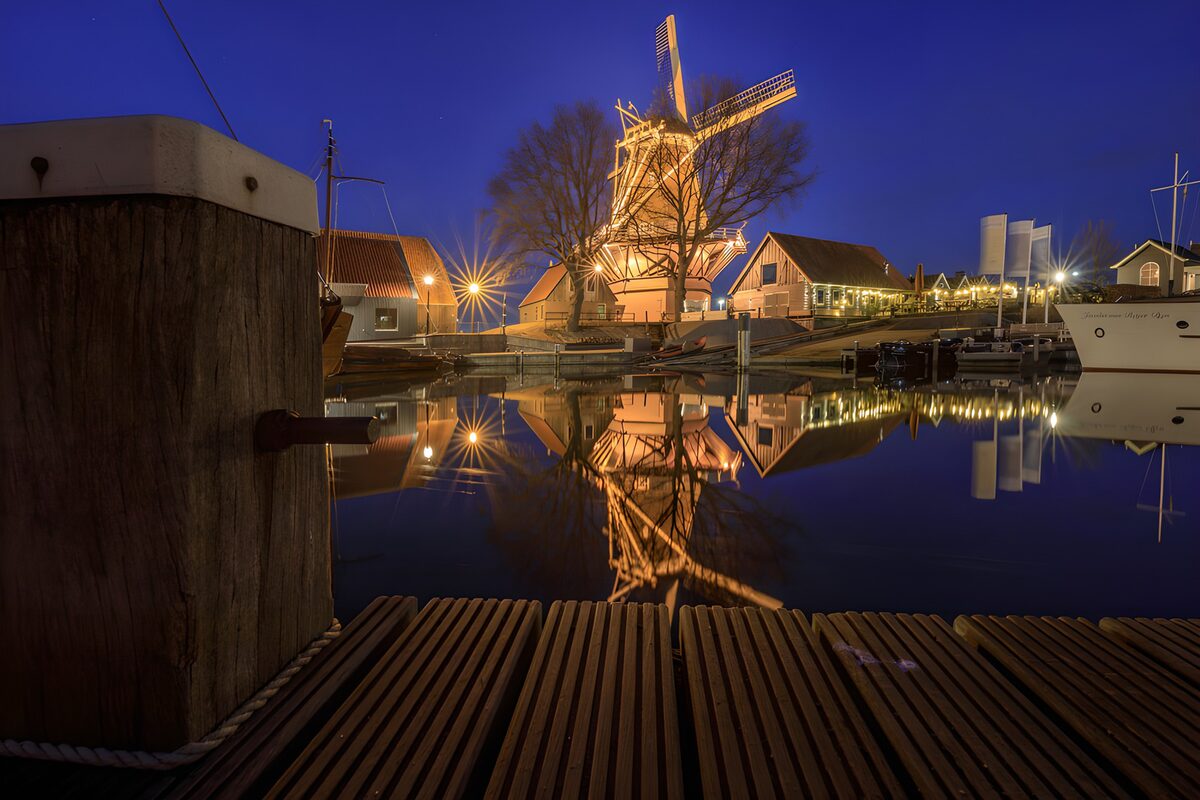 Verlichte molen aan de nachtelijke haven