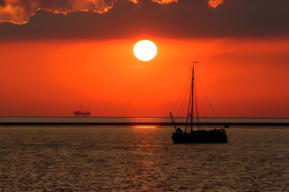 Zeilboot bij een oranjerode zonsondergang