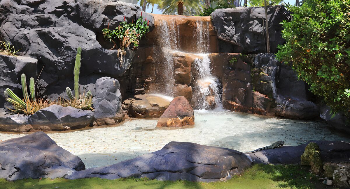 Waterval tussen rotsen en cactussen