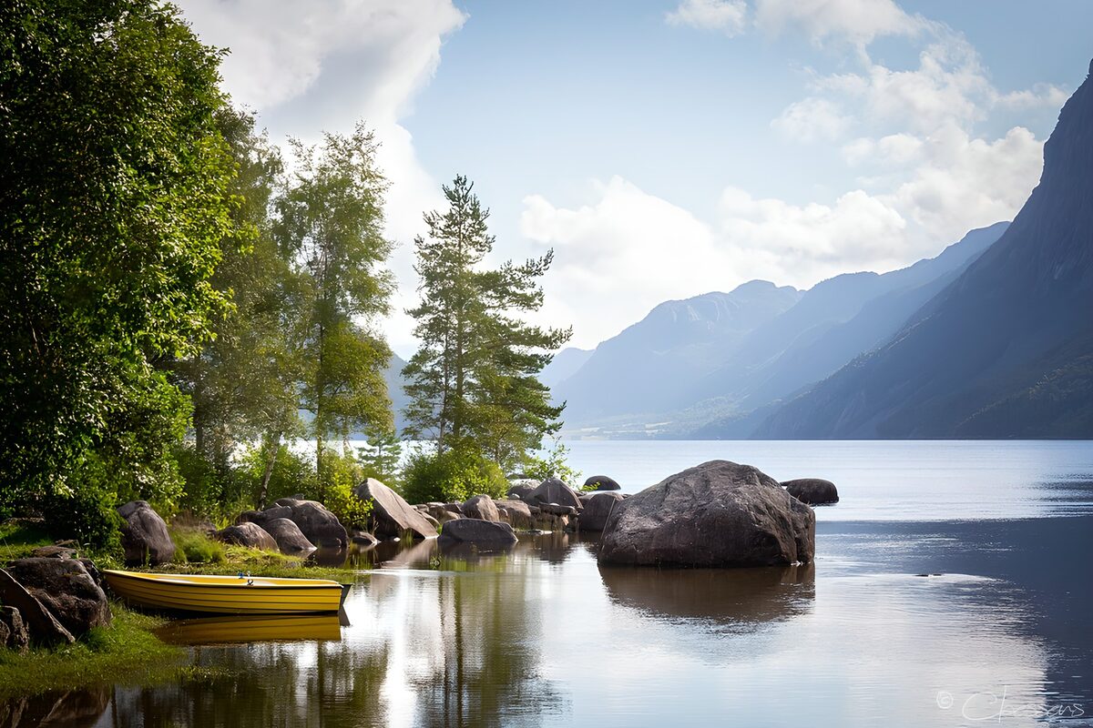 Gele roeiboot aan een stille bergoever