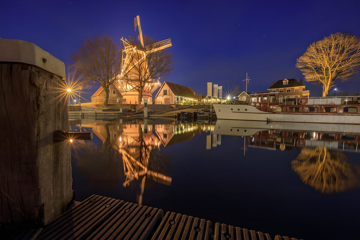 Windmolen en witte boot bij nacht