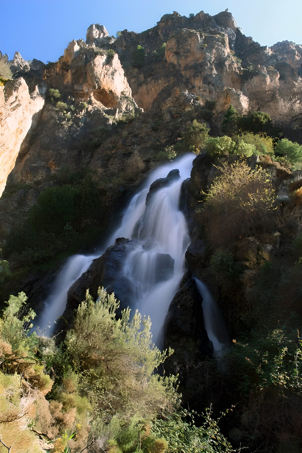 Waterval tussen zonbeschenen rotsen