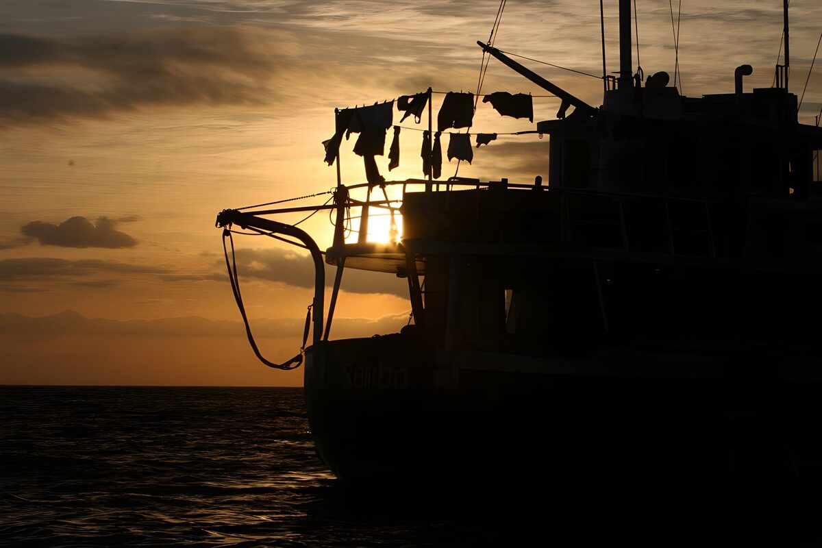 Boot met wasgoed bij zonsondergang