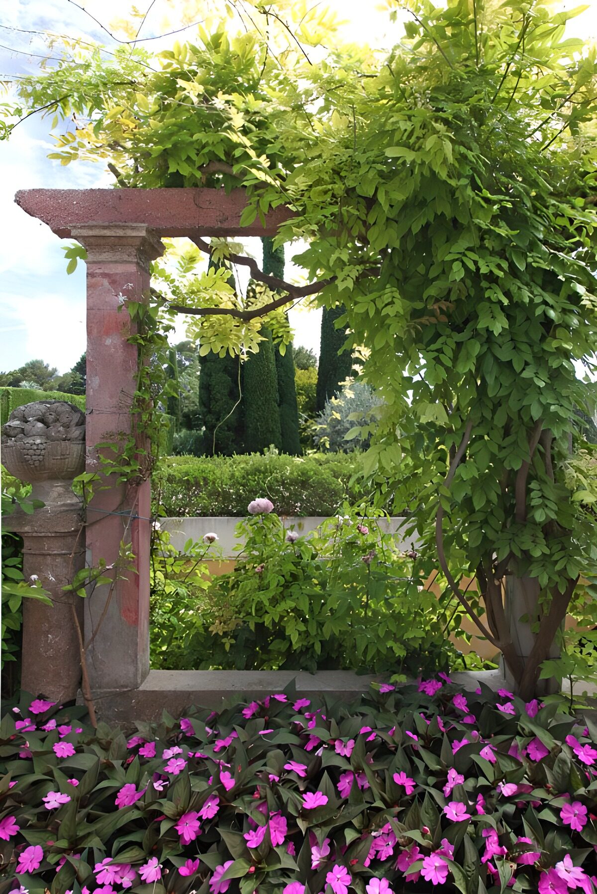 Stenen pergola tussen groen en roze