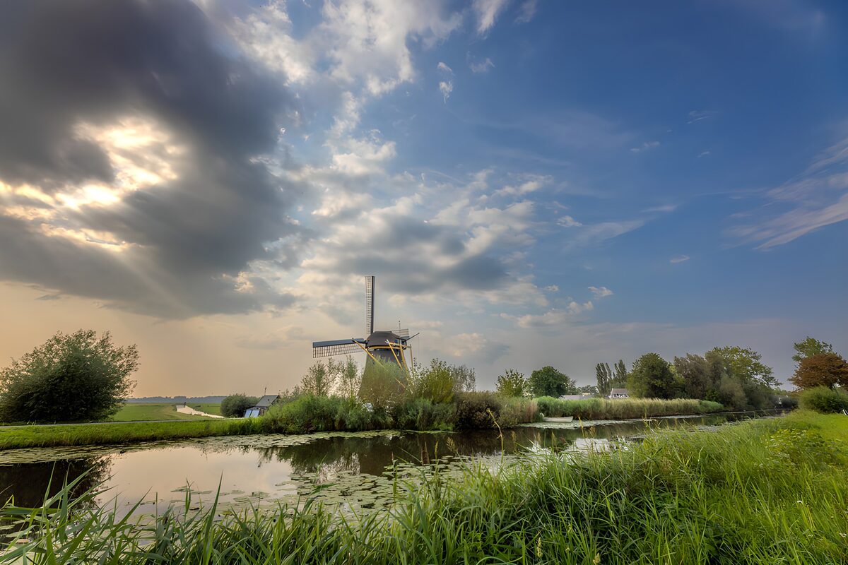 Windmolen aan het water in avondlicht