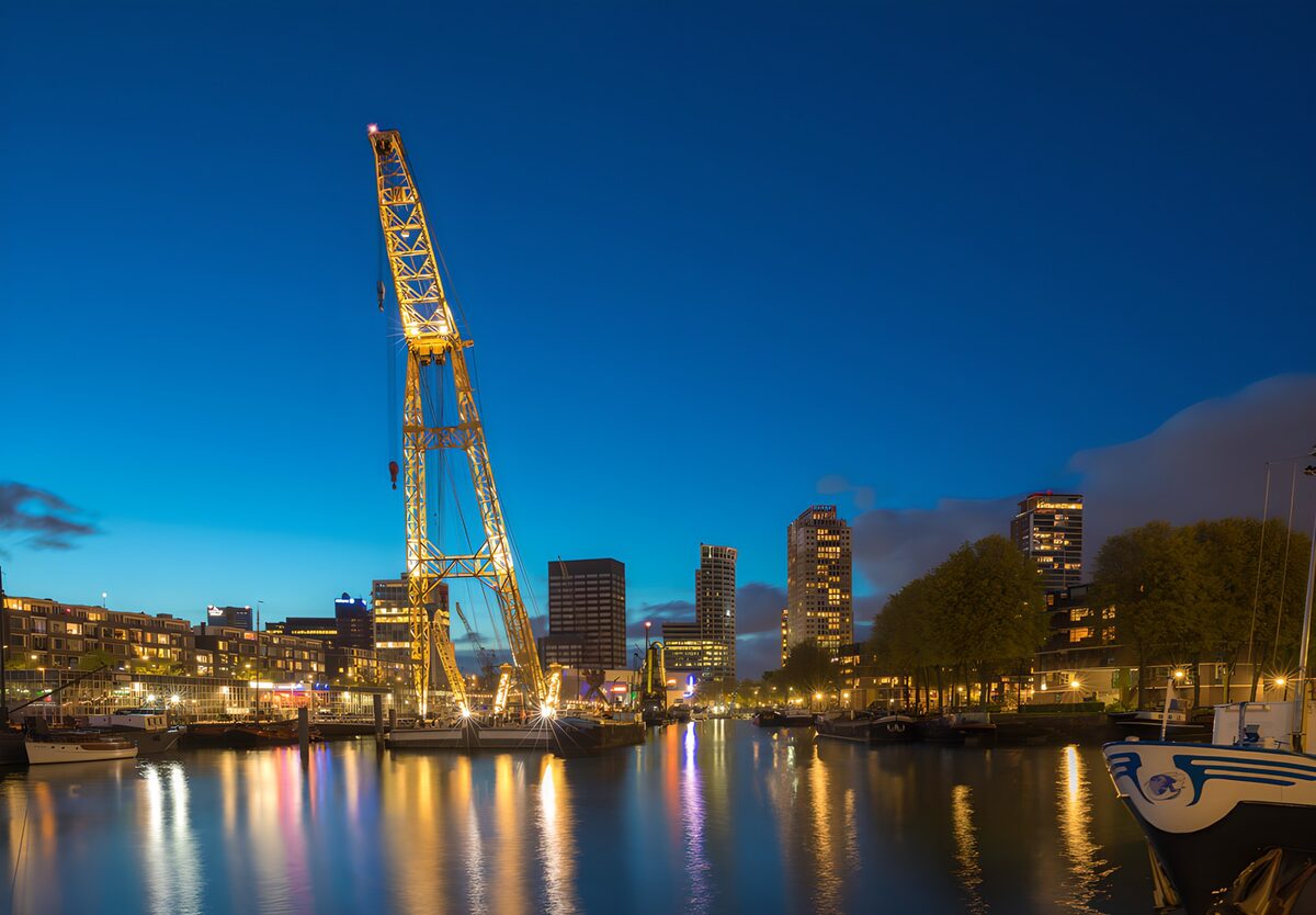 Verlichte havenkraan in de schemering