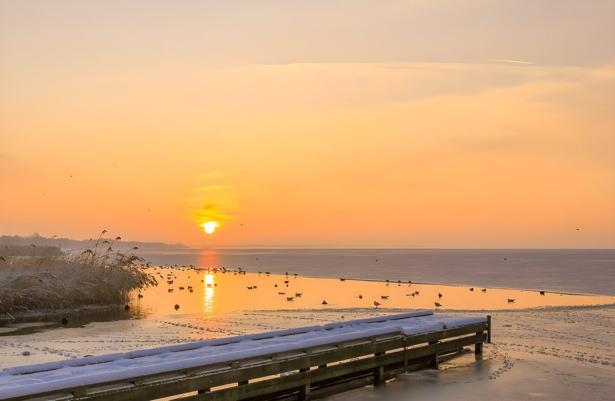 Zonsondergang bij een besneeuwde steiger